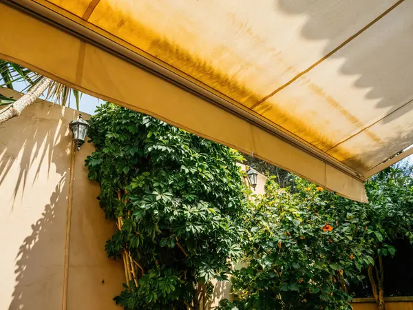 Sun Casts Shadows Yellow Awning Peaceful Mallorcan Patio Surrounded Lush Стокове Фото