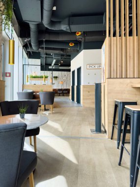 Freiburg im Breisgau, Almanya - Mar 6, 2024: İçinde müşterisi olmayan modern restoran, duvarında tavlama işareti ve şık bir tavan.