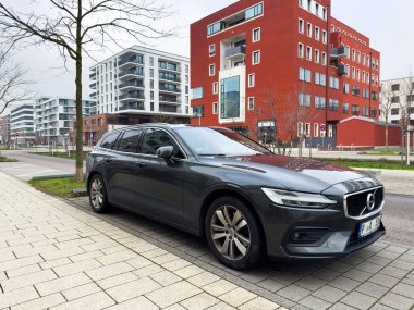 Freiburg im Breisgau, Almanya - 7 Aralık 2024: Freiburg, Almanya 'da park edilmiş lüks bir Volvo vagonu, arka planda güzel binalar.