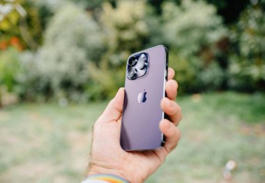 Londra, Birleşik Krallık - Sep 29, 2022: Bir erkek elinde mor bir iPhone 14 Pro açık havada titanyum dereceli paslanmaz çelik gövde ve üç katlı doğal kamera dizisi sergiliyor.