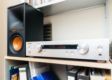 Paris, Fransa - 3 Haziran 2024: Referans serisinden Onkyo P-3000R ön amplifikatörünün Vitsoe rafında bir Klipsch Referans hoparlörünün yanında gösterilen kahramanca çekimi