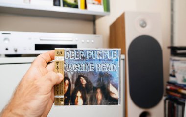 Paris, Fransa - 3 Haziran 2024: Japon Deep Purples Machine Head 'in SACD diskine basılı lüks bir kopyası, lüks bir SACD çalar ve etkileyici bir hoparlörle Japon erkek elinin POV' u