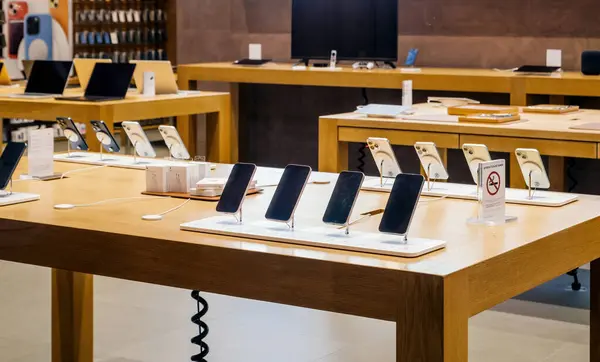 stock image Paris, France - Dec 23, 2023: An Apple store showcases a variety of Apple products, including iPhones, MacBooks, and accessories, neatly displayed on wooden tables in a modern and well-lit retail