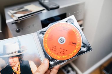 Paris, Fransa - 3 Haziran 2024: Bob Marleys Desire 'ın nadir görülen bir SACD' si, açık bir kutu ve bir amplifikatör ve SACD oynatıcısı da dahil olmak üzere bir yığın işitsel ekipmanla bir erkeğin elinde tutuluyor.