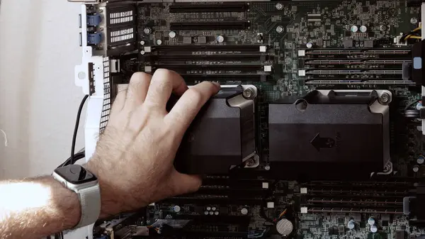 stock image A man installing a second CPU in a powerful workstation for new AI and mathematical model generation, showcasing supercomputer servicing in a high-tech environment