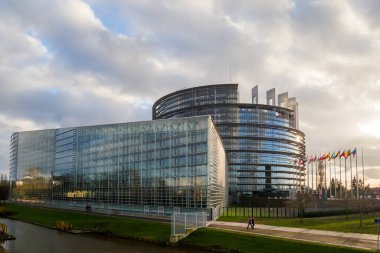 Strasbourg, Fransa - 14 Ocak 2015: Avrupa Parlamentosu binası yakınlarında yürüyen yayalar tüm bayrakları sallıyor, dağınık renkler sergiliyor, canlı ve canlı bir sahne yaratıyorlar