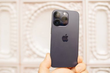 Paris, Fransa - 29 Eylül 2022: Yeni Apple bilgisayarlı iPhone Pro serisi eski cihazlarla modern teknolojinin zıt düşmesi, eski fırın zeminine karşı