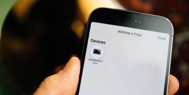 Paris, Fransa - 29 Eylül 2022: Akıllı telefondan MacBook Pro 'ya onaylanmış, kusursuz aktarım protokolünü vurgulayan hava indirme işlemi ele geçirildi