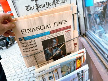 Paris, Fransa - 6 Nisan 2024: Financial Times gazetesini raftan kaldıran bir el, polisin diğer gazetelerle birlikte 600 mn 'lik bir AB dolandırıcılığı baskınında mal varlığına el koymasıyla ilgili başlığı vurguladı