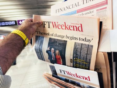 Palma, İspanya - 11 Temmuz 2024: Bir havaalanında FT Weekend Europe baskısını elinde tutan ve göz gezdiren bir adam, Sir Keir Starmer 'ın bir başbakan olarak atanmasıyla ilgili bir başlık