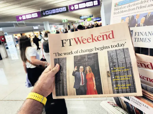 stock image Palma, Spain - Jul 11, 2024: A man holding and reading an FT Weekend Europe edition in an airport, with a headline announcing Sir Keir Starmers appointment as Prime Minister after a historic Labour