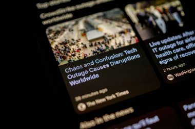 Paris, Fransa - 20 Temmuz 2024: New York Times 'da yayınlanan Kaos ve Karmaşa başlıklı bir iPhone' un yakın çekimi: Teknoloji Kesintisine Yol Açar