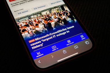 Paris, Fransa - 20 Temmuz 2024: Bir iPhone, CNBC 'de Microsoft-CrowdStrike sorunuyla ilgili bir makale yayınlayarak, ekrandan etkilenen bir grup insanı gösteriyor