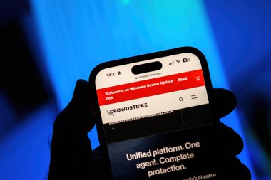 Paris, Fransa - 20 Temmuz 2024: Bir erkek el, Windows Sensör Güncellemesi ile birlikte bir CrowdStrike web sayfasını gösteren bir iPhone tutuyor.