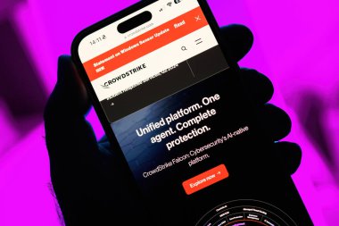 Paris, Fransa - 20 Temmuz 2024: Bakış açısına göre, bir erkeğin elinde bir iPhone, bir CrowdStrike web sitesine büyük çaplı bir küresel bilişim kesintisinin, bir magenta 'ya karşı ele alınmasındaki rollerini gösteren bir web sayfası bulunuyor