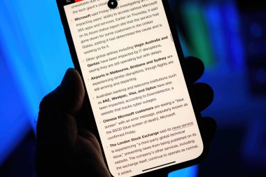 Paris, Fransa - 20 Temmuz 2024: Bir erkek el, CNN Business 'ın Microsoft, Virgin Australia' ı etkileyen küresel bilişim bozulmalarıyla ilgili detaylı bir makalesini gösteren bir iPhone tutuyor