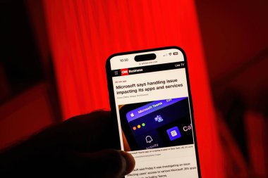 Paris, Fransa - 20 Temmuz 2024: Bir erkek el, CNN Business 'ın uygulamalarını ve hizmetlerini etkileyen sorunlarla ilgili bir makalesini gösteren bir iPhone tutuyor,