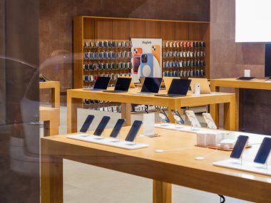 Paris, Fransa - 23 Aralık 2023: Birden fazla MacBook Pro bilgisayarı ve iPhone kasası sergilenen Apple Store iç mimarisi, mağazaların şık tasarımlarını gece geç saatlerde müşterileri olmadan gösteriyor