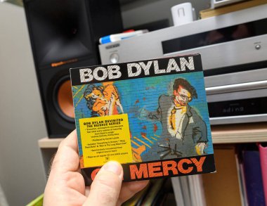 Paris, Fransa - 18 Mart 2024: Onkyo ve Klipsch 'in yüksek kurgu sistemi ile birlikte Columbia Records tarafından gözden geçirilen yeniden basım serisinden Bob Dylans Oh Mercy' nin SACD 'sini elinde tutan bir erkeğin POV' si