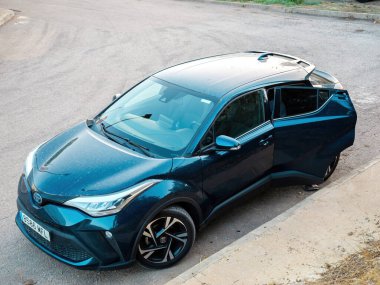 Inca, İspanya - 9 Temmuz 2024: Şehirde park halindeki Toyota Hybrid SUV 'nin sürücü kapısı açık, binaların ve sokak unsurlarının yer aldığı kentsel bir zemin üzerine kurulmuş, kentsel bir anı yakalayan