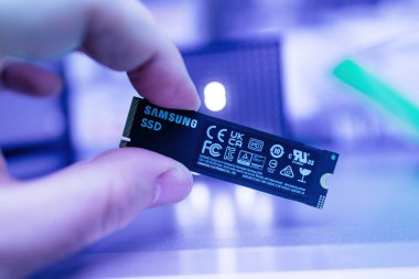 Paris, Fransa - 3 Nisan 2024: Bir erkek el Samsung SSD NVMe ultra hızlı bir diske sahip bir müşteri iş istasyonu laptopunun güncellenmesi sırasında, yenisini veya yükseltme kısmını birden fazla parçayla gösterir