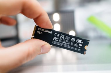 Paris, Fransa - 3 Nisan 2024: Bir erkek el, Samsung SSD NVMe ultra hızlı bir diske sahip, bir müşteri iş istasyonu bilgisayarının güncellenmesi sırasında, değiştirilmiş ya da güncellenmiş bir parçaya odaklanarak