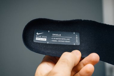 Berlin, Almanya - 19 Ekim 2019: Nike Kalkanı yazıtının G90 su püskürtücü materyali, Odyssey React modeli ve Just Do It 'in yer aldığı Nike koşu ayakkabısının tabanına yakın plan çizimi