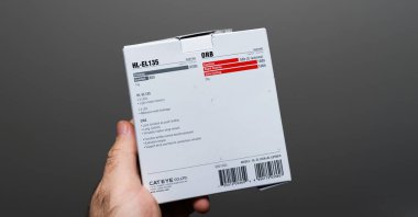 Paris, Fransa - 1 Nisan 2024: Üzerinde HL-EL135 ORB etiketli beyaz bir ürün kutusu bulunan bir el, ürünlerin çalışma zamanı, LED özellikleri ve barkodları hakkında ayrıntılı bilgi