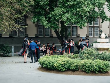 Bakü, Azerbaycan - 21 Ağustos 2023: Mezunlar, başlık ve cüppelerdeki başarılarını kutlamak amacıyla Bakü, Azerbaycan 'daki yemyeşil bir avluda toplandılar.