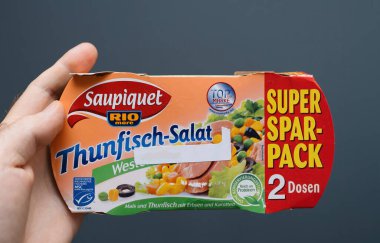 Berlin, Almanya - 22 Ekim 2019: Bir paket Saupiquet Rio Mare Thunfisch-Salat ton balığı salatası tutan, ürün ambalajını gösteren ve kolaylık ve markaların altını çizen bir el