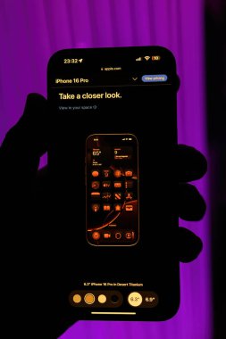 Paris, Fransa - Sep 8, 2024: Yeni Desert Titanium rengini sergileyen iPhone 16 Pro Max 'i tutan bir erkeğin dikey çekimi. Uyumlu uygulama renk entegrasyonu