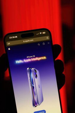 Paris, Fransa - 8 Eylül 2024: iPhone 16 Pro Max 'i elinde tutan bir erkeğin dikey çekimi kırmızı arka planda, 