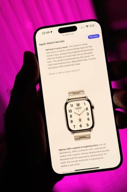 Paris, France - Sep 8, 2024: A male hand holding a smartphone with the Apple Store website open, displaying the pre-order page for the Apple Watch Ultra 2 Herm s with the Sporty Sophistication slogan clipart