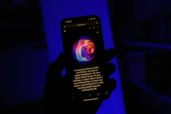 stock image Paris, France - Sep 8, 2024: Square shot of a male hand holding the iPhone 16 Pro Max with a green background, featuring the swirling Apple logo from the latest keynote introduction. Highlights