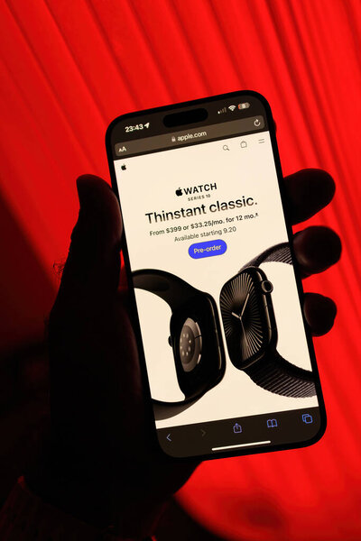 Париж, Франция - 8 сентября 2024 года: Мужская рука держит iPhone 16 Pro Max показывая новый Apple Watch Series 10 в черном титане, с начальной ценой 399 долларов США и финансирования доступны в 33,25 месяца