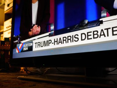 Paris, Fransa - 11 Eylül 2024: Oturma odasında bir televizyon, canlı izleme partisi sırasında Donald Trump ve Kamala Harris arasında canlı yayına odaklanmış konuklarla başkanlık tartışması sunuyor.