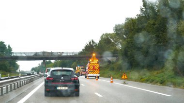 Strasbourg, Fransa - Sep 8, 2024: Fransa otobanında yağmurla kaplı bir arabanın ön camından, önümüzde kötü hava koşullarını vurgulayan bir kazadan dolayı tehlike işareti gösteren bir güvenlik kamyonuyla