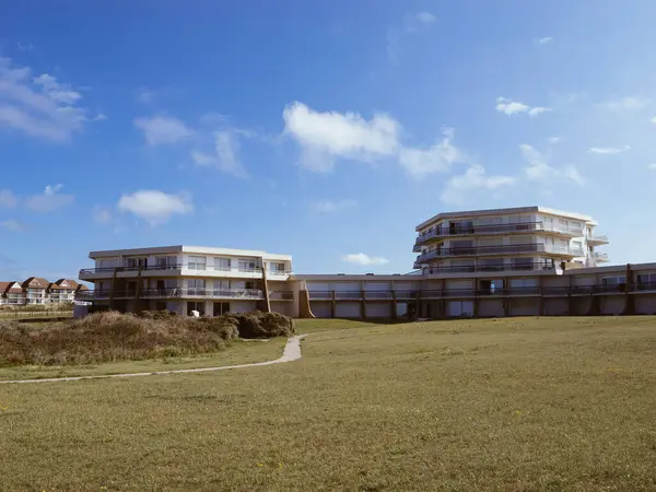 stock image Holiday house buildings with large apartments, windows, balconies, and a lawn in front under a clear blue sky in Hardelot, France