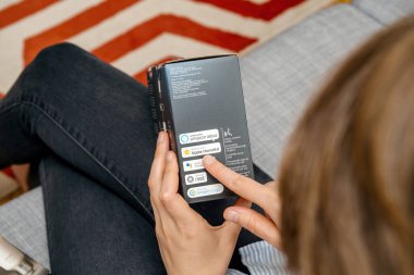 Paris, France - Aug 16, 2019: A woman holds the Philips Hue Bridge package, reading that it works with Alexa, Apple HomeKit, Google Nest, and SmartThings voice activation ready, made in China clipart