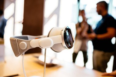 Paris, Fransa - 20 Ekim 2024: Apple Vizyon Pro uzaysal bilgisayarının arka planda Apple Mağazası içindeki odaklanmış müşterileri ile yan görünümü