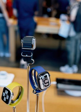 Paris, Fransa - Sep 20, 2024: Apple Watch 10 serisi, Apple Store 'da, arka planda müşterileri olan SE ve Ultra 2 modellerinin yanındaki sunum standında sergilendi - kahraman nesne