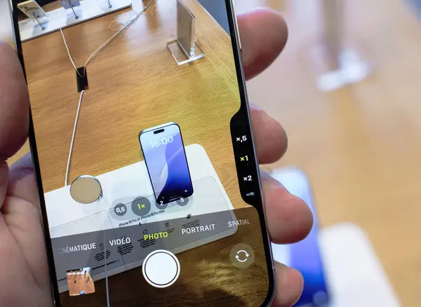 stock image Paris, France - Sep 20, 2024: Close-up POV of male hand testing the Camera Control Button on the iPhone 16 Pro, adjusting exposure, styles, and ISO with haptic feedback