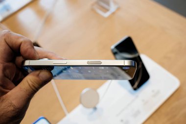 Paris, Fransa - 20 Sep 2024: iPhone 16 Pro 'nun titanyum çerçevesini tutan erkek elinin POV' u ayarlamalar için haptik geri bildirimli bir Kamera Kontrol Düğmesi.
