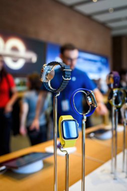Paris, Fransa - 20 Ekim 2024: Apple Store 'un arka planda Apple Genius siluetleri olan sahnesi. En son Apple Watch 10 Serisi ve Ultra 2 'yi sergileyen tanınmayan bir kişi kahraman nesnesini elinde tutuyor.