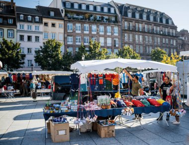 Strasbourg, Fransa - 20 Sep 2024: Kleber Meydanı, Strasbourg 'da birden fazla kıyafet satan adam, arka planda Haussmann binaları, müşterileri bekliyor