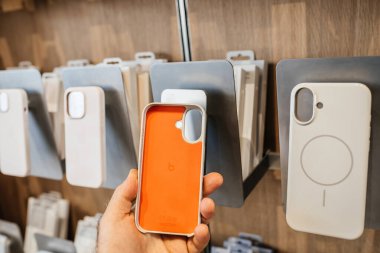 Paris, Fransa - 20 Şubat 2024: Bir Beats Ses çantasının turuncu arka kısmını mıknatıslarla şarj eden indüksiyon halkalarını içeren iPhone 16 Pro Max için tutan erkek el