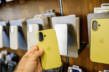 Paris, Fransa - 20 Sep 2024: iPhone 16 Pro Max için elmalı silikon çanta tutan bir erkeğin POV 'u endüksiyon halkaları ve mıknatısları şarj ediyor.