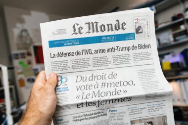 Paris, Fransa - 20 Mayıs 2024: Elinde tuttuğu ve okuduğu Fransız Le Monde gazetesi ile Joe Biden 'dan Metoo' ya kadar olan dünya çapında güncel haber başlıkları