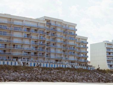 Hardelot, France - Aug 20, 2023: View of a large seaside apartment building with balconies in Hardelot, France, overlooking rocks and coastal scenery clipart