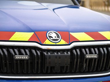 Neufchatel-Hardelot, Fransa - 18 Ağustos 2023: Kaputta yansıtıcı kırmızı ve sarı güvenlik işaretleri bulunan bir Skoda polis aracının ön ızgarasının yakın çekimi, araç yasasının altı çizili